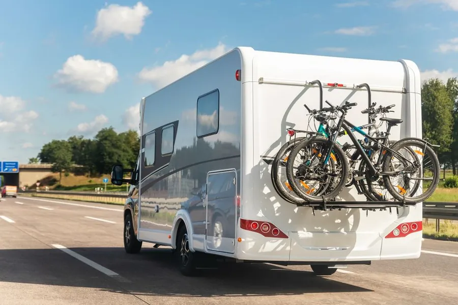 Autocaravana con bicicletas en la parte trasera circulando por una autopista