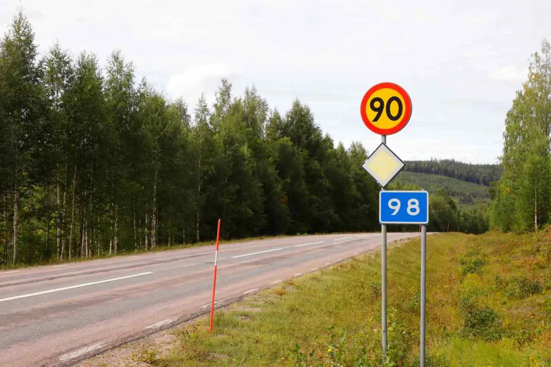 Señales suecas de 90 km/h, vía con prioridad y carretera 98 junto a una carretera forestal