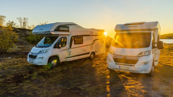 Dos autocaravanas aparcadas una junto a otra al atardecer