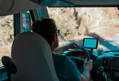 Conductor al volante de una autocaravana, con un GPS en el salpicadero