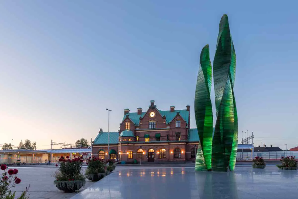 Estación central de Umeå con una escultura de cristal verde al anochecer