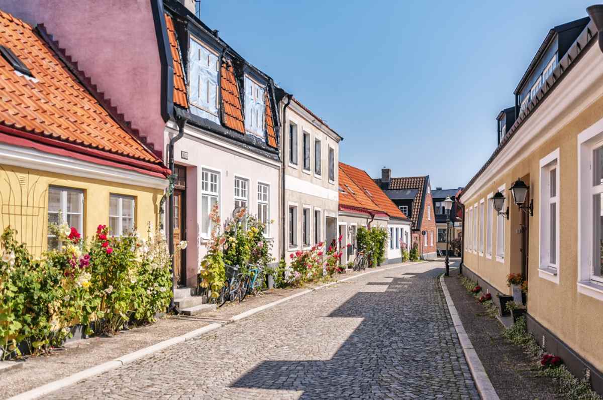 Färgglada hus och kullerstensgata i Ystad – skånsk småstadscharm och lugn körning under en roadtrip i Sverige.