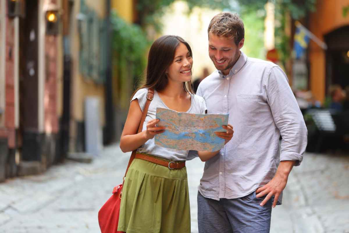 Par som läser en karta på kullerstensgata i Gamla stan – praktiska tips för roadtrip i Sverige: navigering, planering och smarta stopp.