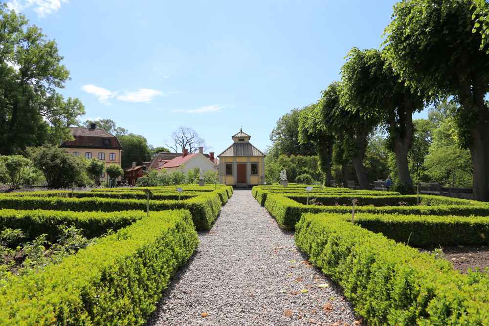 Overview of gardens located at the Skansen Open-Air Museum in Stockholm on a beautiful sunny day.