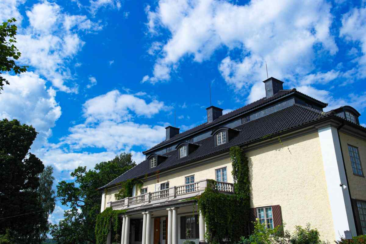 Herrgården Mårbacka i Värmlands län, Sverige, hem för författaren Selma Lagerlöf, med murgröna på väggarna och blå himmel.