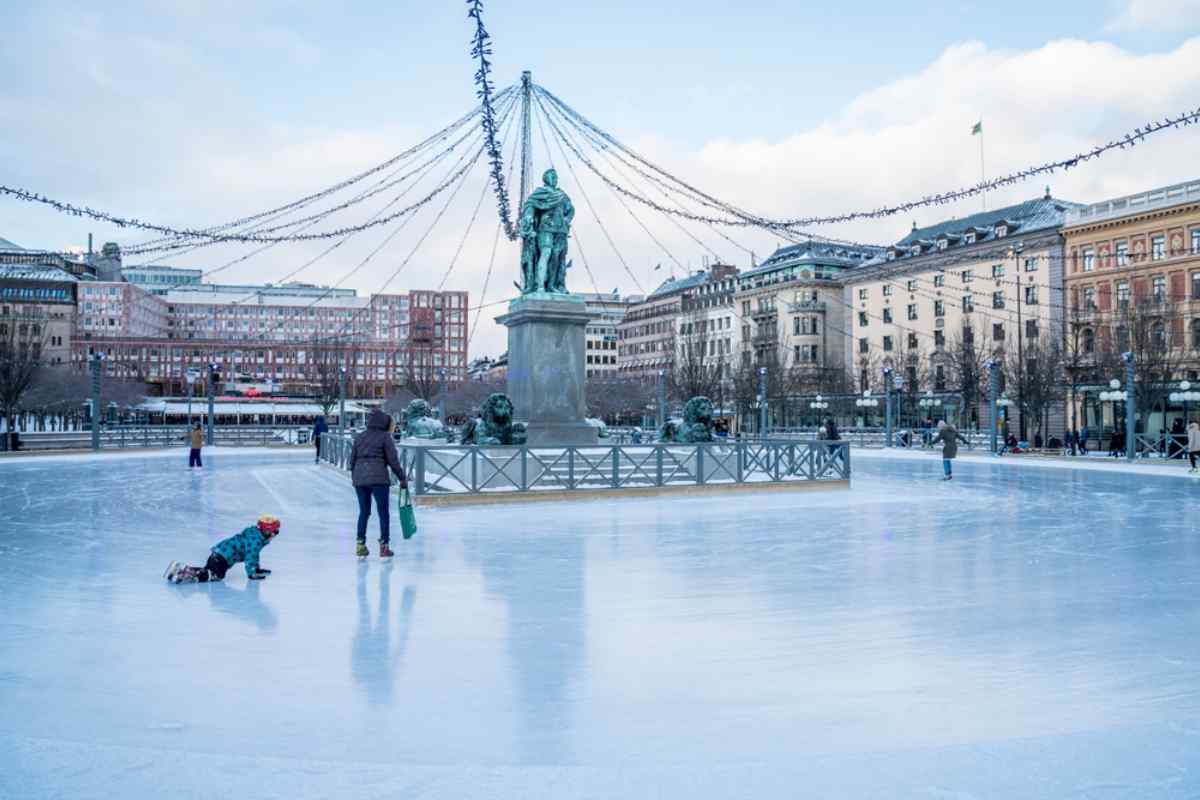 Vinterscen av en isrink i Kungsträdgården, Stockholm, med flera personer som åker skridskor.