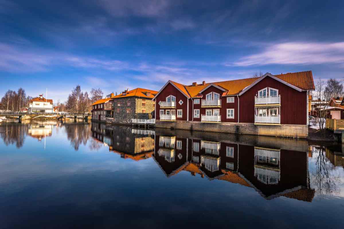 Allmän vy över färgglada trähus i Falun, Sverige, speglade i det lugna vattnet runt staden.
