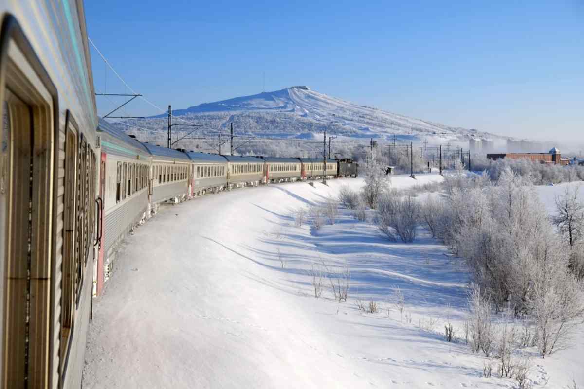 Allmän vy av ett tåg som svänger på en kurva framifrån i ett snötäckt svenskt landskap.