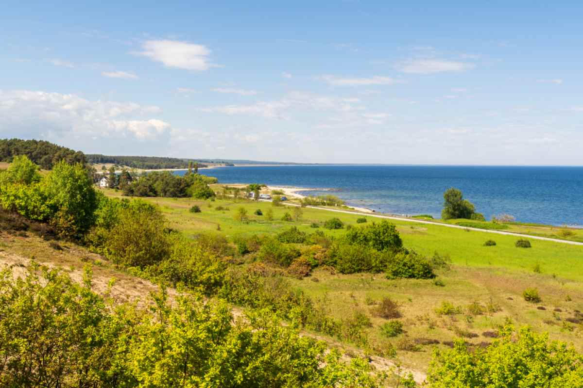 Green coastal meadows and a sandy beach meeting the Baltic Sea near Kivik in Österlen, southern Sweden.