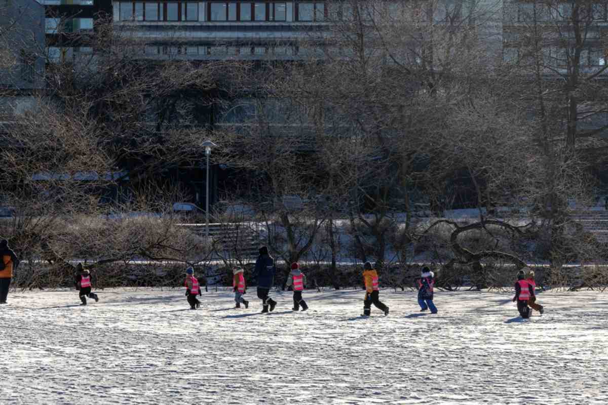 Übersicht über Trekanten in Stockholm, wo mehrere Kinder in warmen Overalls Schlittschuh laufen.