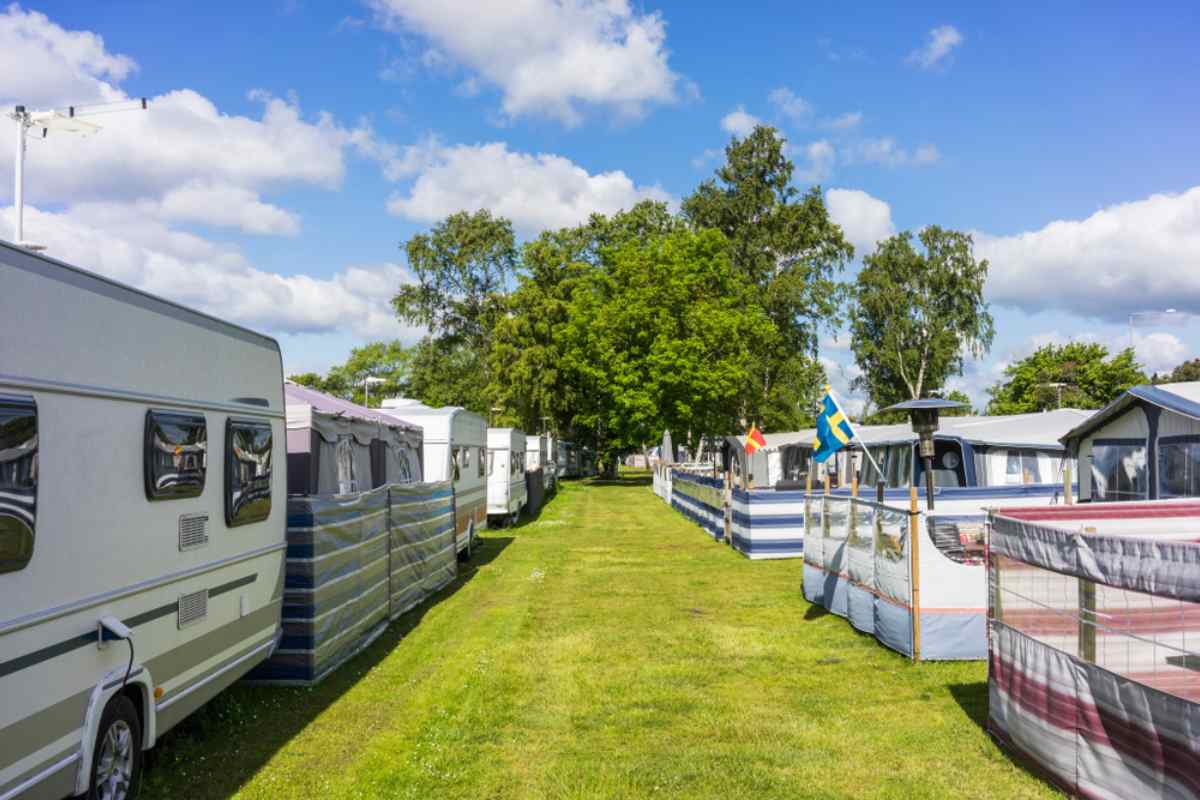 Reihe von Wohnwagen mit Vorzelten auf einem familienfreundlichen Campingplatz in Schweden an einem sonnigen Sommertag.