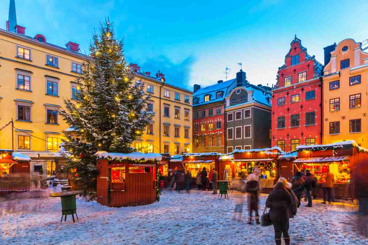 Einer der bekanntesten Plätze in Schweden, dekoriert während der Weihnachtszeit mit Lichtern und Weihnachtsmärkten, unter einer dicken Schneeschicht, die den Boden und die Dächer bedeckt.