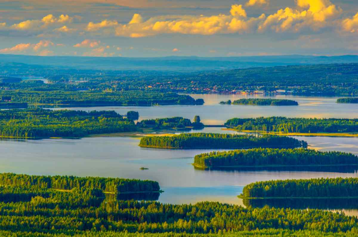 Drone view of Sweden's Lake Siljan during a sunset with the last lights of the day illuminating the many islands covered with green vegetation within.
