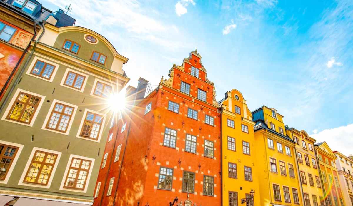 Allgemeine Ansicht der charakteristischen bunten Gebäude der Stockholmer Altstadt mit Sonnenstrahlen, die hindurchscheinen.