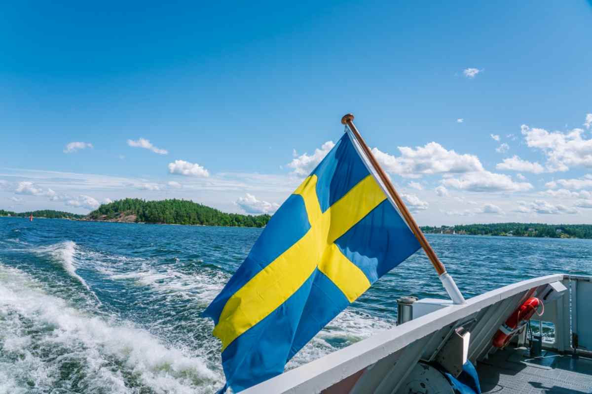 Detailaufnahme einer Flagge auf einem Schiff, das durch den Stockholmer Schärengarten fährt.