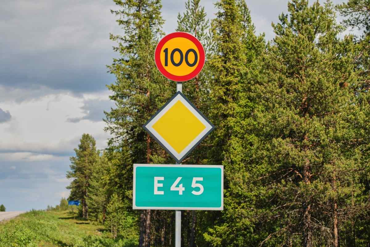 E45 road in Sweden E45 highway sign and priority road marker in a pine forest.