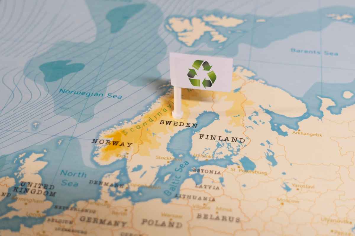 Map of Scandinavia with a recycling flag pinned on Sweden, symbolizing sustainable road trips and eco-friendly excursions from Stockholm.