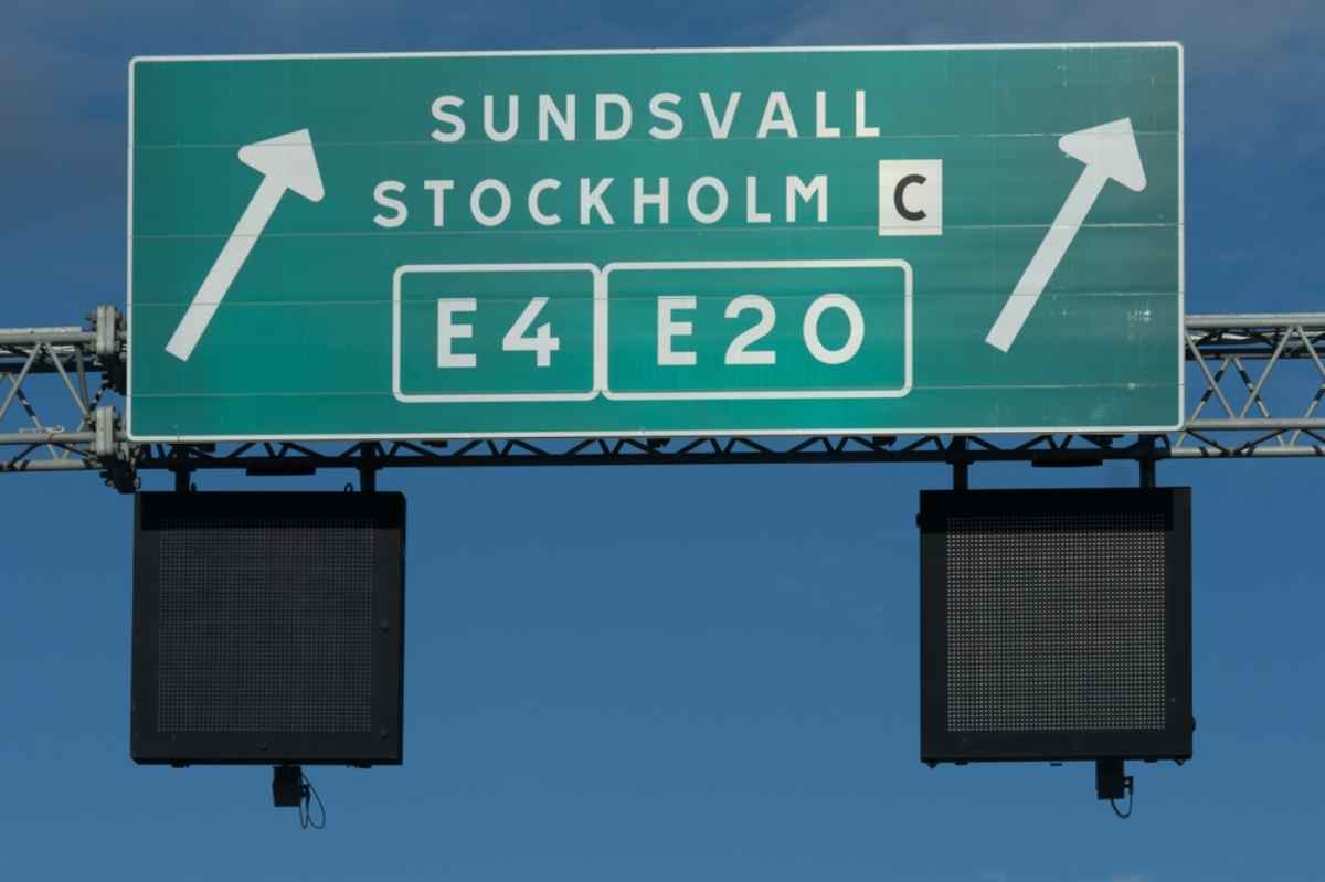 Overhead motorway sign for E4 and E20 toward Stockholm C and Sundsvall, main routes for driving in Sweden.