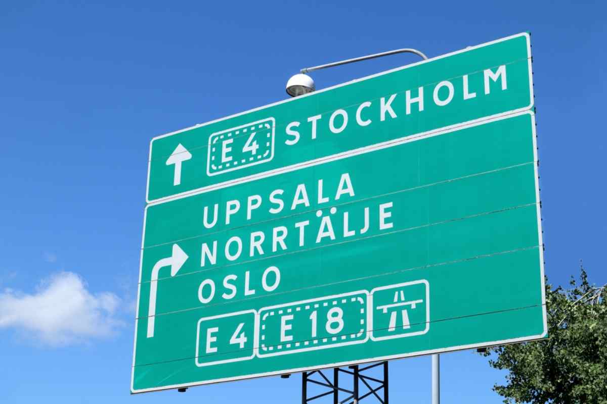 Green E4 road sign pointing to Stockholm, Uppsala, Norrtälje, and Oslo, key highway routes for a Sweden road trip.