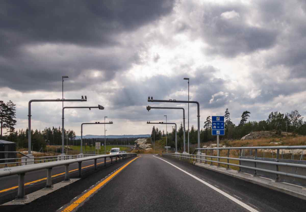 Norwegens AutoPASS Norwegische Schnellstraße mit AutoPASS-Mautportalen unter bewölktem Himmel, aus Fahrersicht.