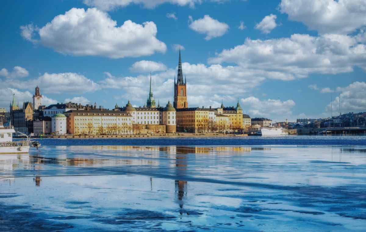 Stockholms Gamla Stan Blick auf Gamla Stan in Stockholm, mit historischen Gebäuden, die sich in teilweise gefrorenem Wasser spiegeln.