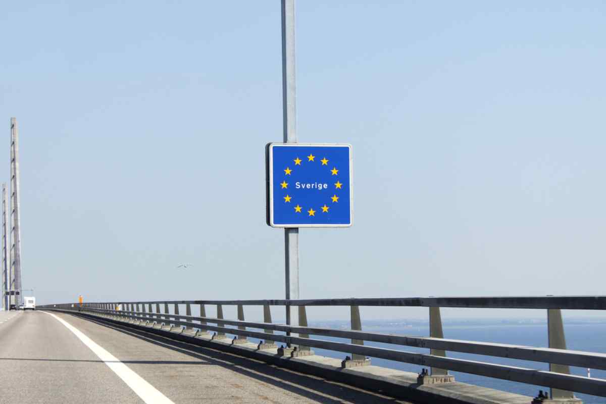 Warum der Schengen-Raum bei Reisen in Schweden wichtig ist Verkehrsschild auf einer Brücke über offenes Wasser, das die Einreise nach Schweden innerhalb des Schengen-Raums markiert.