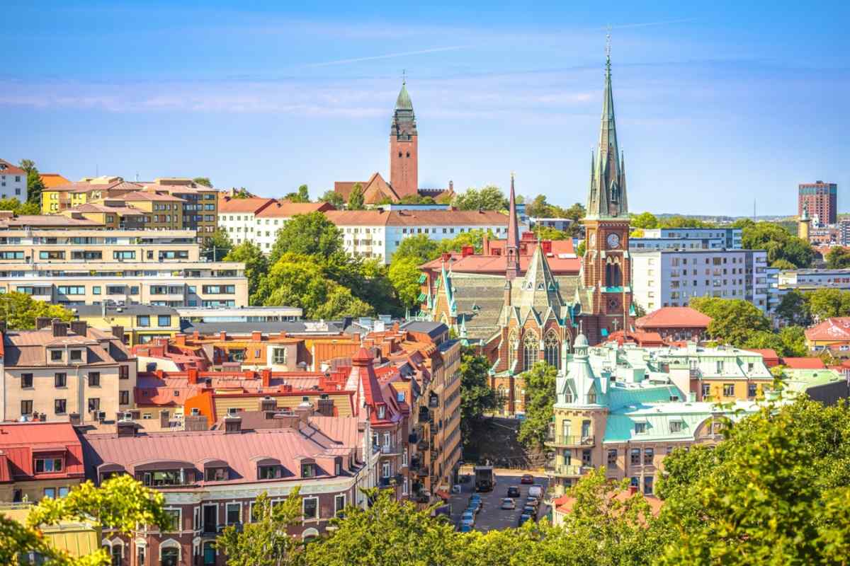 Panoramablick auf Göteborg mit bunten Dächern und hohen Kirchtürmen an einem sonnigen Tag.